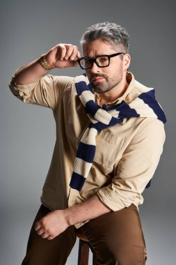 Gözlüklü yakışıklı, modaya uygun bir stüdyo ortamında zahmetsiz stil ve cazibe sergiliyor..