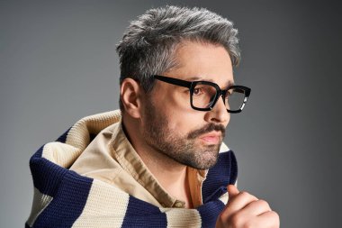 Yakışıklı adam kendine güvenen bir şekilde poz veriyor. Stüdyoda şık görünümüne dikkat çekiyor..