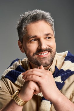 Yakışıklı bir adam modaya uygun bir şekilde poz verir. Stüdyoda kendine güveni ve cazibesi vardır..