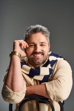 Tüylü, modaya uygun bir adam modern bir stüdyoda poz veriyor, cazibesi ve tarzı var..