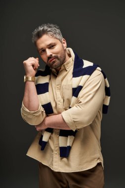 Tüylü yakışıklı bir adam, kendine güvenen şık bir kıyafet içinde, modern moda eğilimlerini somutlaştırıyor..