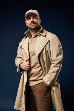 Tüylü şık bir adam şık kıyafetini şık bir arka planda sergiliyor..