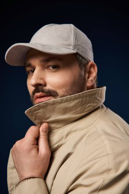 Tüylü yakışıklı bir adam, kendine güvenen şık bir elbise içinde, büyüleyici bir şekilde poz verir..