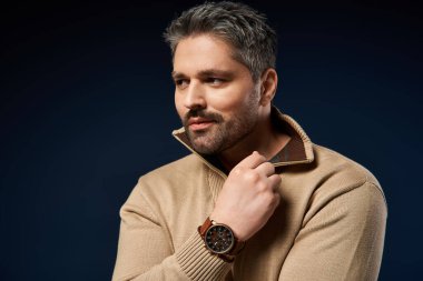 Yakışıklı bir adam moda kıyafetleri içinde, moda anlayışını ve tarzını ön plana çıkarıyor..