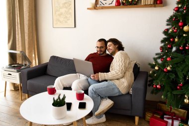 İki adam evlerinde neşeli bir anı paylaşıyor, kahkahalarla şenlikli atmosferin tadını çıkarıyorlar..