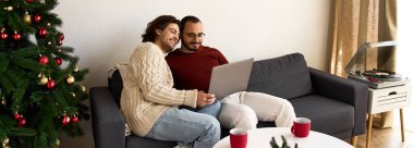 İki neşeli adam evlerinde dizüstü bilgisayar paylaşıyor, tatillerde kucaklaşıp anılar yaratıyorlar..