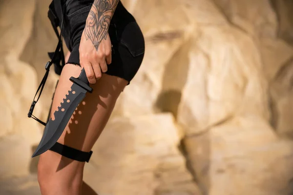Teilaufnahme eines tätowierten Archäologen in kurzen Hosen mit Holster und Messer — Stockfoto