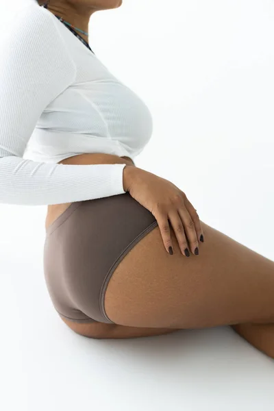 Vue recadrée de femme afro-américaine posant en chemise à manches longues et culotte isolée sur blanc — Photo de stock