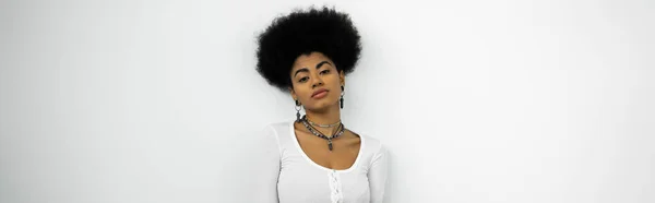 Афроамериканка у сорочці з довгим рукавом дивиться на камеру ізольовану на білому плакаті. — стокове фото