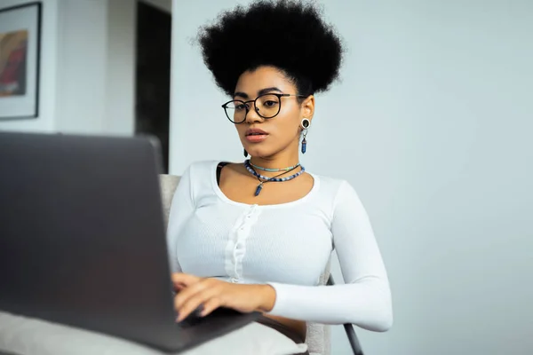 Focada mulher americana africana em óculos usando laptop em casa — Fotografia de Stock