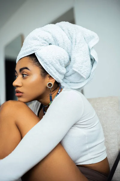 Jolie femme américaine africaine avec serviette sur la tête regardant loin à la maison — Photo de stock