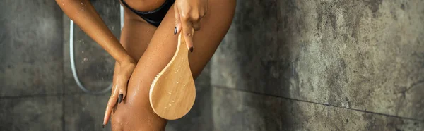 Cropped view of african american woman holding massage brush in shower cabin, banner — Stock Photo