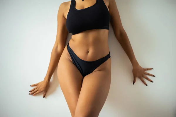 Vue recadrée de femme américaine africaine sexy en sous-vêtements toucher mur — Photo de stock