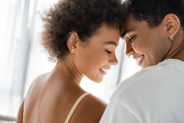 Curly african american woman and man with piercing smiling with closed eyes — Stock Photo