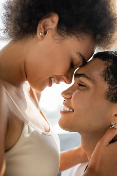 Vista lateral do casal afro-americano sorridente cara a cara em casa — Fotografia de Stock