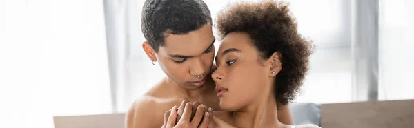 Homme afro-américain torse nu et femme brune bouclée tenant la main à la maison, bannière — Photo de stock