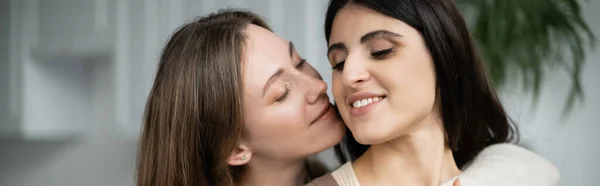 Lesbian woman hugging and kissing partner at home, banner — Stock Photo