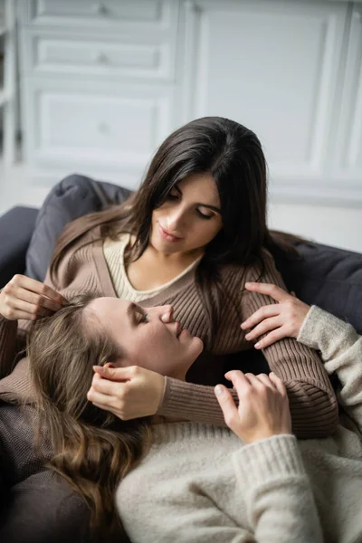 Junge lesbische Frau berührt Freundin, während sie sich zu Hause auf Couch ausruht — Stockfoto