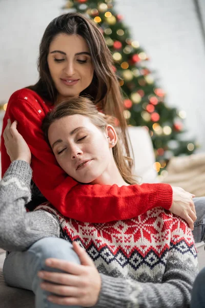 Unscharfe lesbische Frau umarmt Freundin im warmen Pullover zu Hause — Stockfoto