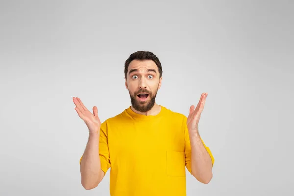 Amazed man showing wow gesture while looking at camera isolated on grey — Stock Photo