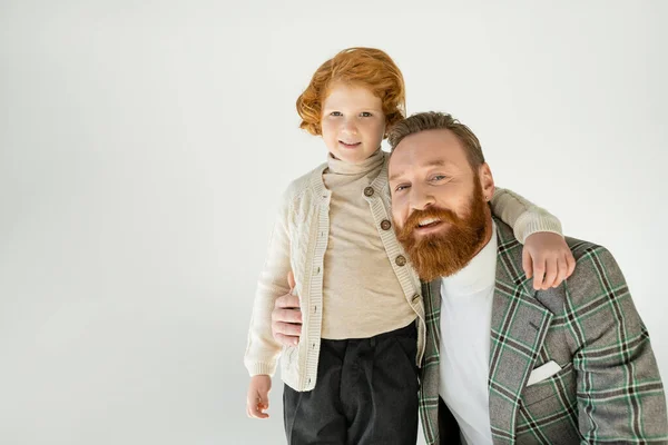 Smiling bearded father hugging redhead son isolated on grey — Stock Photo