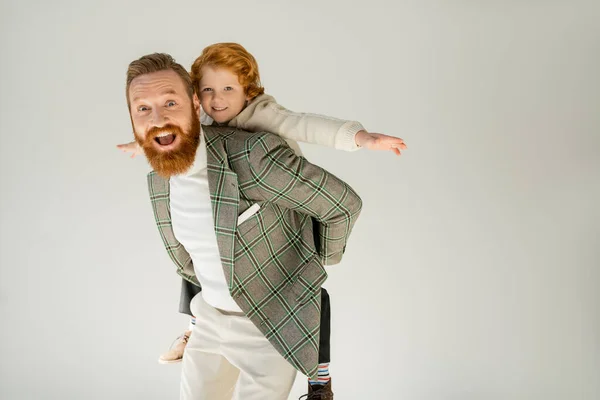 Aufgeregte bärtige Vater spielen mit Sohn isoliert auf grau — Stockfoto