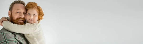 Joyeux garçon rousse étreignant papa élégant isolé sur gris avec espace de copie, bannière — Photo de stock
