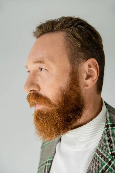 Бородатий чоловік у плетеній куртці дивиться ізольовано на сірому — стокове фото