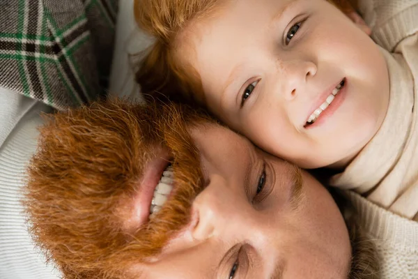 Top view of cheerful bearded man with redhead son looking at camera — Stock Photo