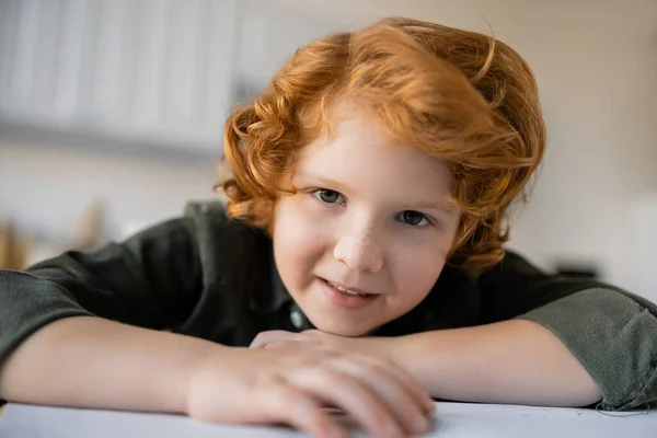 Retrato de menino encaracolado com cabelo vermelho e sardas sorrindo para a câmera em casa — Fotografia de Stock