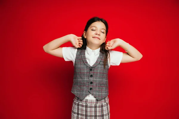 Pleased girl with closed eyes stretching arms isolated on red, banner — Stock Photo