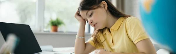 Tired schoolgirl sitting with closed eyes near laptop with blank screen, banner — Stock Photo