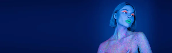 Nackte Frau in leuchtendem Neon-Make-up und buntem Farbspritzer auf dunkelblauem Hintergrund, Banner — Stockfoto