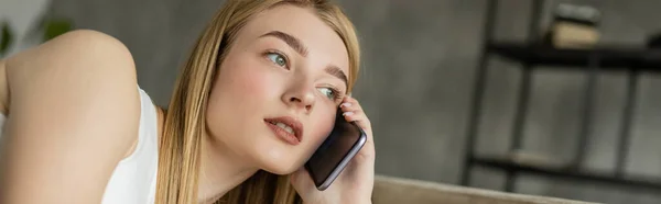 Красива жінка розмовляє на мобільному телефоні у вітальні, банер — стокове фото