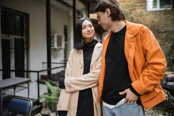 Souriant asiatique femme regardant élégant petit ami en plein air café — Photo de stock