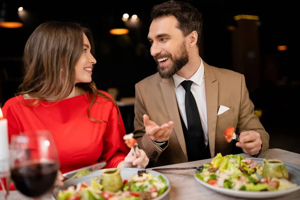 Lächelndes junges Paar in festlicher Kleidung beim Reden während der Feier am Valentinstag — Stockfoto