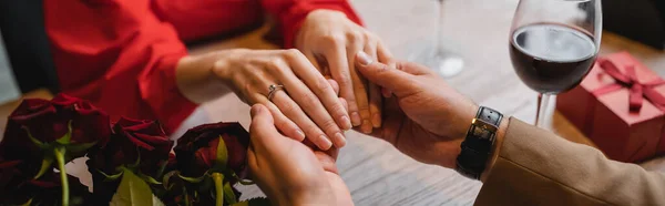 Ausgeschnittene Ansicht einer Frau mit Verlobungsring am Finger, Händchen haltend mit Mann am Valentinstag, Banner — Stockfoto