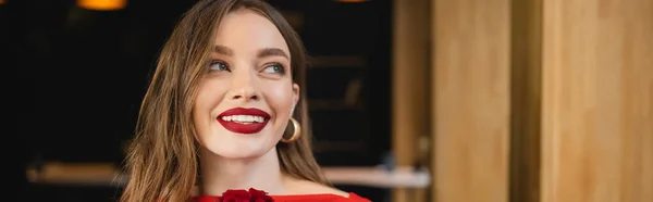 Cheerful young woman with red lips smiling near rose on valentines day, banner — Stock Photo
