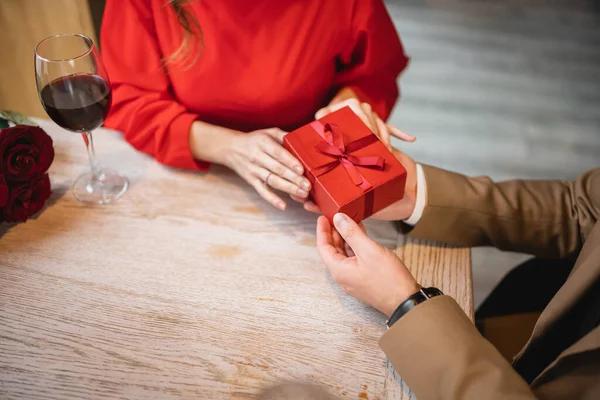 High angle view of cropped man holding wrapped present near young woman on valentines day — Stock Photo