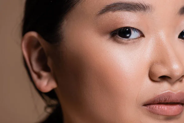Cropped view of young asian woman looking at camera isolated on brown — Stock Photo