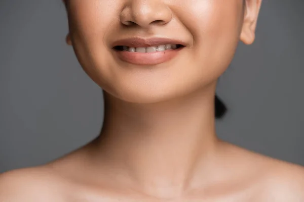 Cropped view of young woman with naked shoulders smiling isolated on grey — Stock Photo