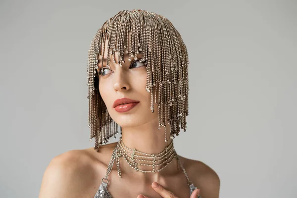 Stylish model in jewelry headwear looking away isolated on grey — Stock Photo