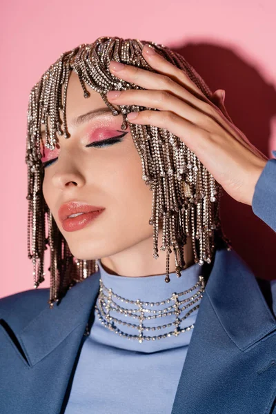 Portrait of trendy woman with makeup touching jewelry headwear on pink background — Stockfoto