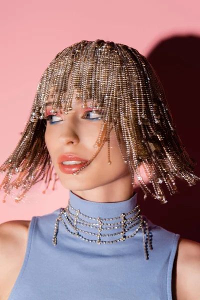 Motion blur of stylish woman in jewelry headwear looking away on pink background — Photo de stock