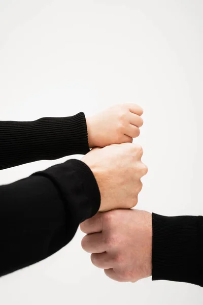 Partial view of boy and adult men joining fists isolated on grey — Stock Photo