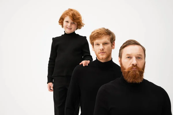 Happy red haired boy touching shoulder of father near bearded grandpa isolated on grey — Stock Photo