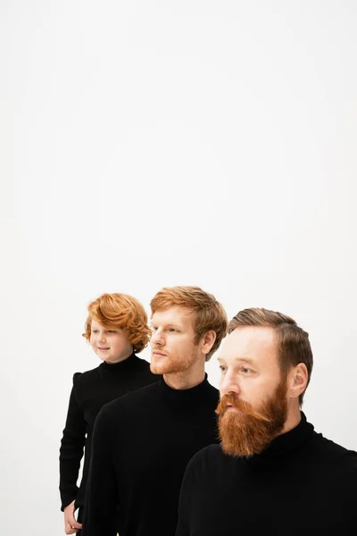 Redhead men and happy kid in black pullovers looking away isolated on grey with copy space — Stock Photo