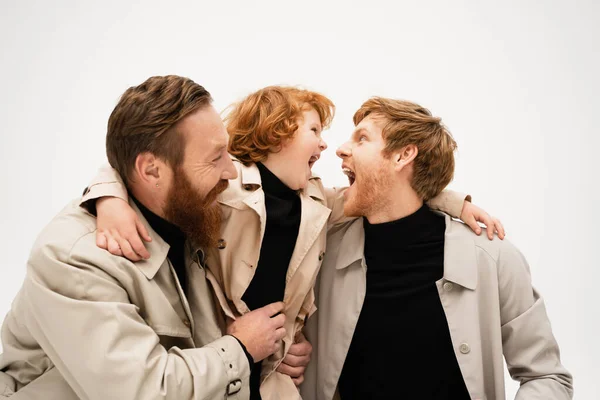 Redhead and bearded man smiling near excited son and grandson having fun isolated on grey — Foto stock