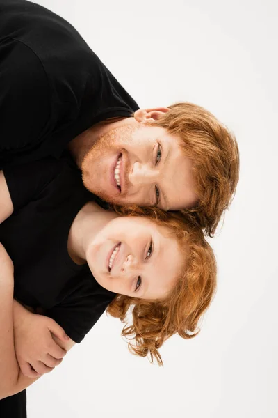 Young and cheerful man with redhead son having fun while looking at camera isolated on grey — Stock Photo