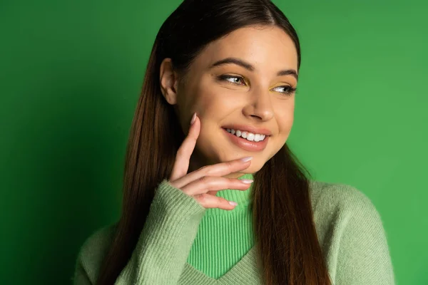 Portrait of smiling teenager in jumper posing on green background — Stock Photo